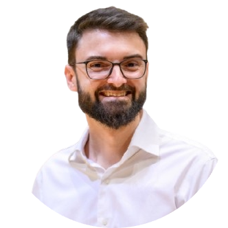 Marc smiling, wearing glasses and a white shirt
